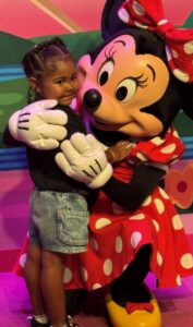 Ashlynn hugs Minnie Mouse at Disney World during her dream trip with Toby’s Dream Foundation.