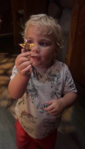 Child named Cooper holding a golden star souvenir with a look of wonder during his Disney trip.