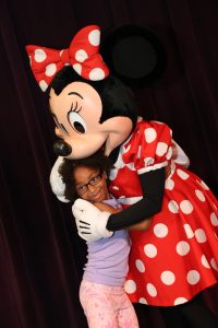 Girl hugging Minnie Mouse during a Disney World character meet.